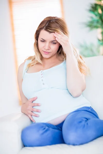 Pregnant woman having headache on couch — Stock Photo, Image