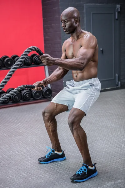 Joven culturista trabajando con cuerdas — Foto de Stock