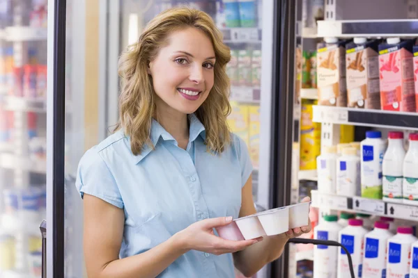 Ritratto di una donna sorridente che ha sulle mani uno yogurt fresco — Foto Stock