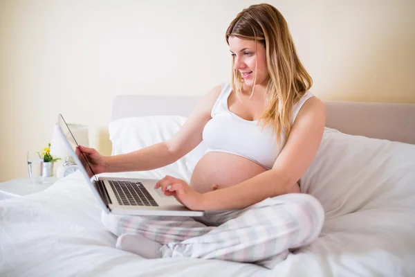 Mulher grávida usando computador portátil — Fotografia de Stock