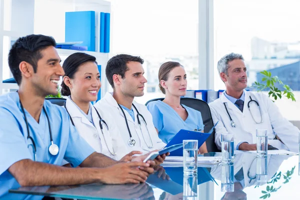 Doctors listening while sitting at a table — Stock Photo, Image