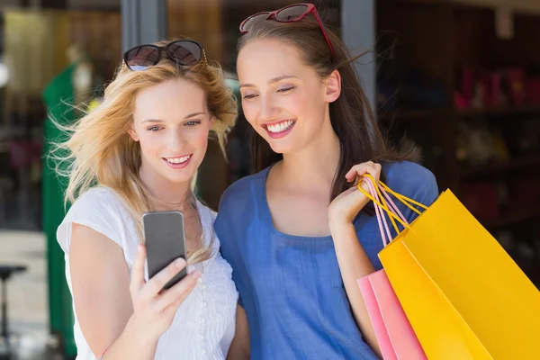 Happy smiling friends looking at smartphone — Stock Photo, Image