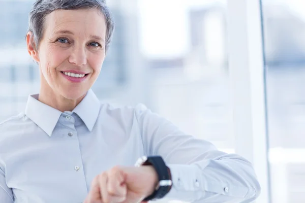 Smiling businesswoman using her smartwatch — Stock Photo, Image