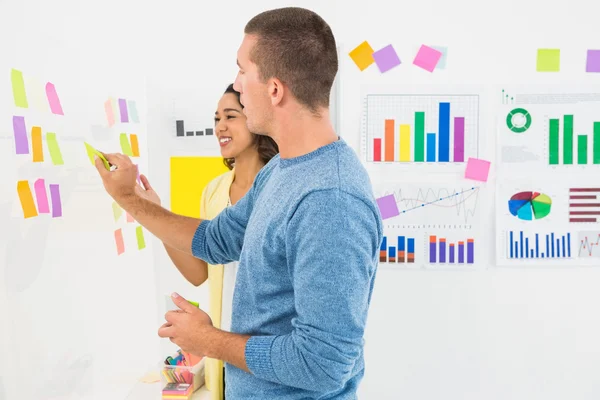 Smiling coworkers reading sticky notes — Stock Photo, Image