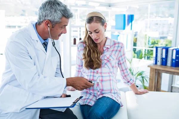 Doctor examining a pregnant woman with a stethoscope — Stock Photo, Image