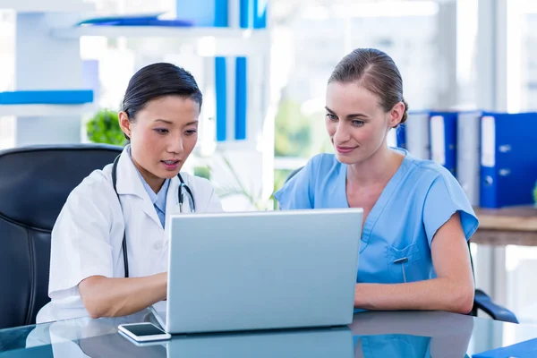 Médico e enfermeiro olhando para laptop — Fotografia de Stock