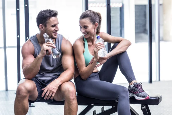 Muscular couple discussing on the bench — Stock Photo, Image