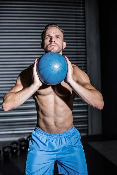 Мускулистый человек делает упражнения с мячом — стоковое фото