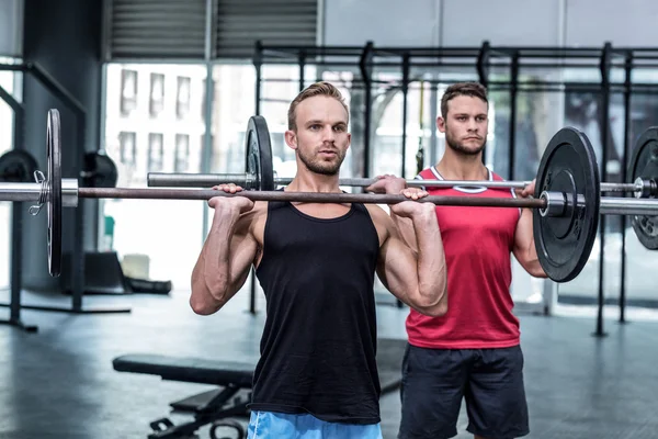 Hombres musculares levantando una barra — Foto de Stock