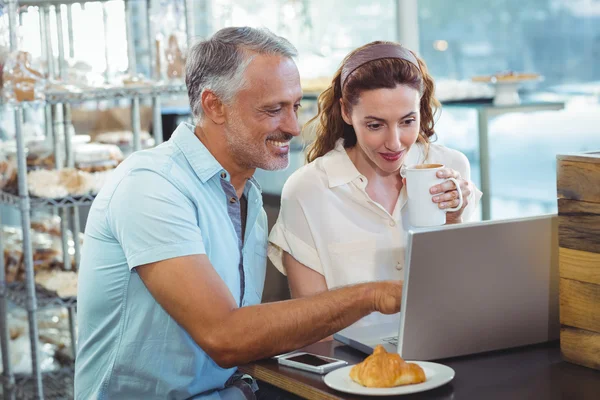 Casal feliz apontando algo no laptop — Fotografia de Stock