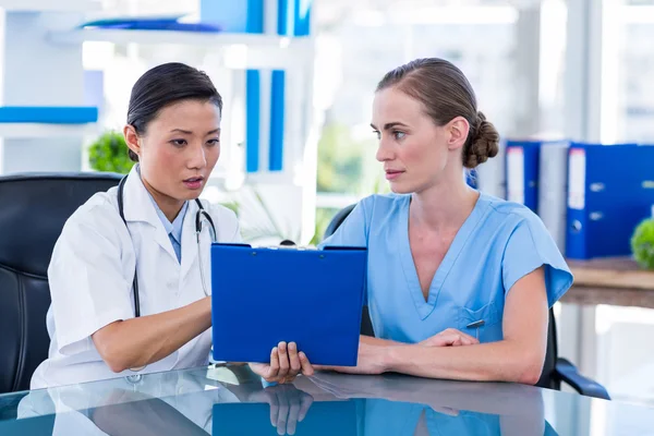 Doctor and nurse looking at clipboard — Stock Photo, Image