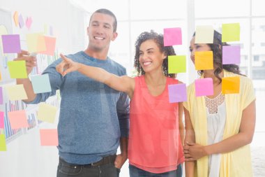 Smiling coworkers pointing sticky notes clipart