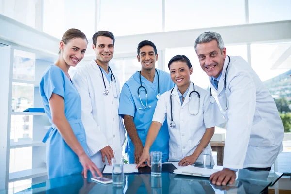 Médicos y enfermeras sonriendo a la cámara — Foto de Stock