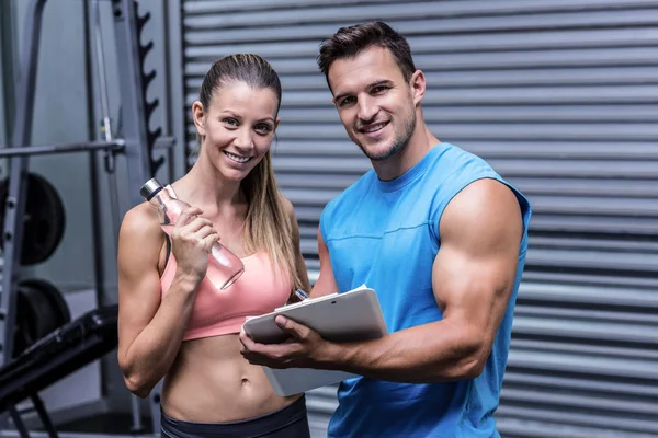 Muscular woman watching her results on clipboard — Stock Photo, Image