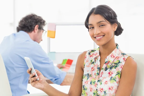 Businesswoman standing and using smartphone — Stockfoto