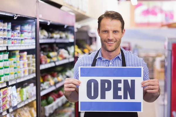 Retrato de un guapo sonriente sosteniendo un cartel — Foto de Stock