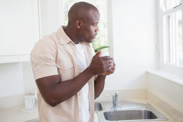 Ein Mann nimmt seinen Tee und schaut nach draußen — Stockfoto