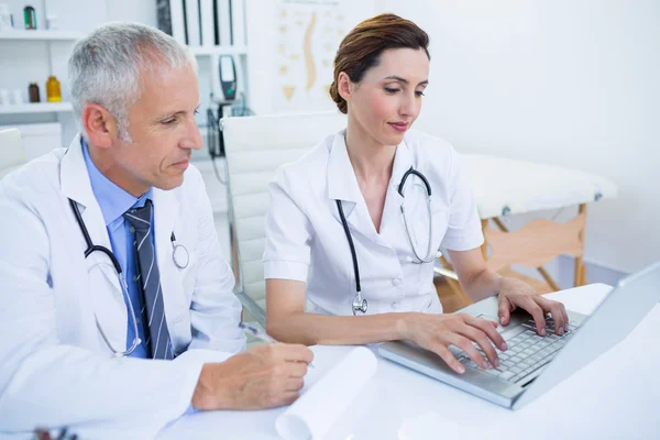 Lachende medische collega's werken met laptop — Stockfoto