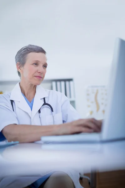 Médica feminina usando seu computador portátil — Fotografia de Stock