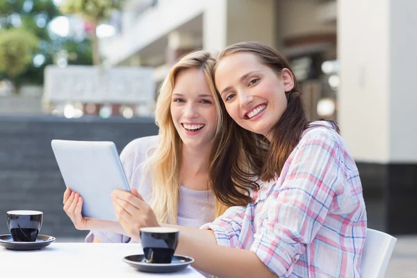 Happy women friends holding tablet — Stock Photo, Image