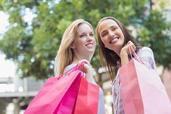 Mulheres felizes com sacos de compras olhando para longe — Fotografia de Stock