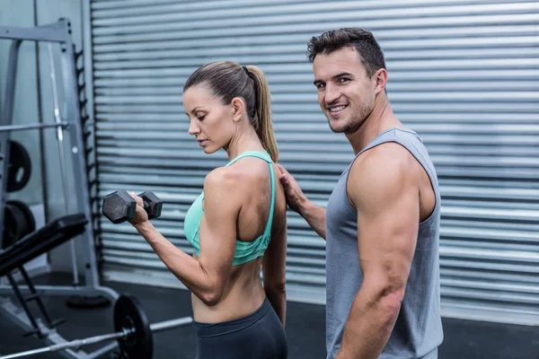 A muscular woman lifting dumbbells — Stock Photo, Image