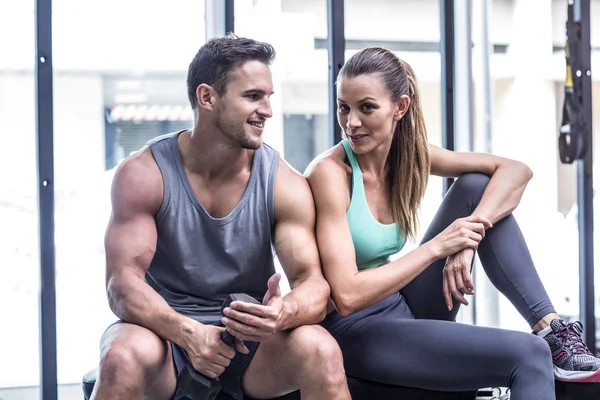Muskulöses Paar sitzt auf der Bank — Stockfoto