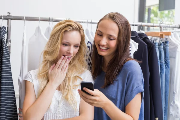 Fassungslose Freunde, die auf ein Smartphone schauen — Stockfoto