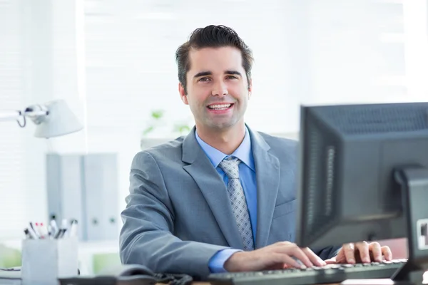 Empresário sorridente usando seu computador — Fotografia de Stock