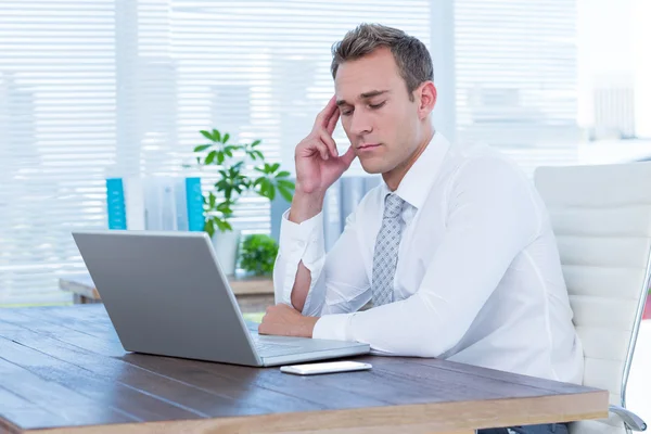 Empresário exausto se afogando em seu laptop — Fotografia de Stock