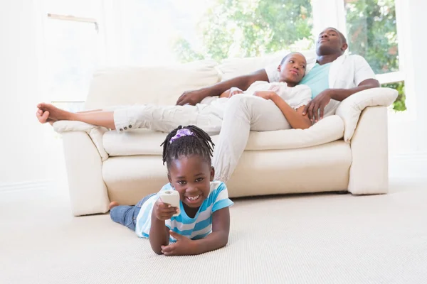 Ganska par sitter på soffan och deras dotter spelar — Stockfoto