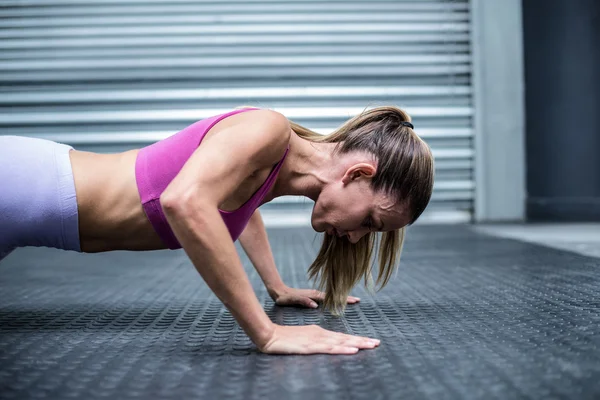 Mulher muscular fazendo flexões — Fotografia de Stock