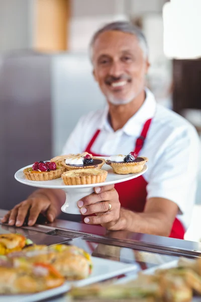 Barista holding a plate of pastries — Stock Photo, Image