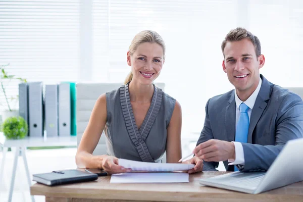 Happy colleagues working together on laptop and folder — Stock Photo, Image