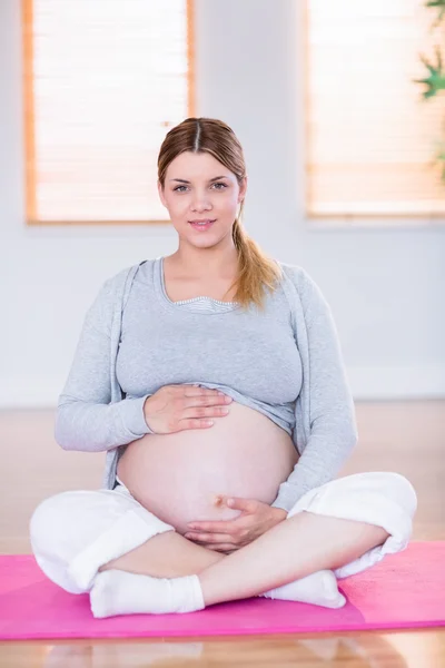 怀孕的妇女抱着她的肚子 — 图库照片