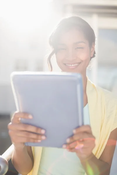 Casual zakenvrouw glimlachen op camera houden van tablet-pc — Stockfoto