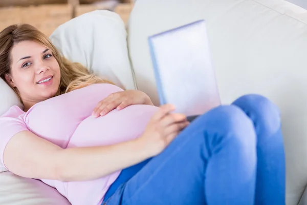 태블릿을 사용 하 여 웃는 임신한 여자 — 스톡 사진