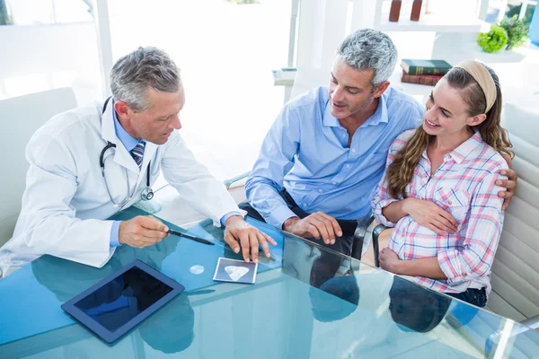 Donna incinta e suo marito discutono con il medico — Foto Stock