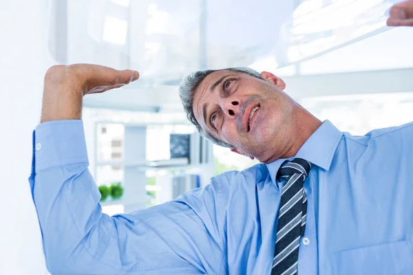 Un hombre de negocios serio levantando algo — Foto de Stock