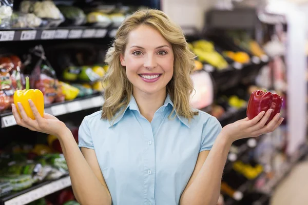 Portrait d'une femme blonde souriante ayant un légume sur son han — Photo