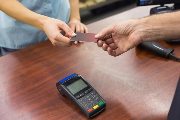 Frau an der Kasse bezahlt mit Kreditkarte — Stockfoto