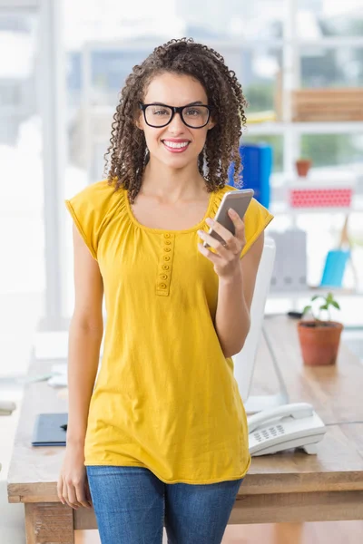 Sorridente giovane donna d'affari in possesso di uno smartphone — Foto Stock