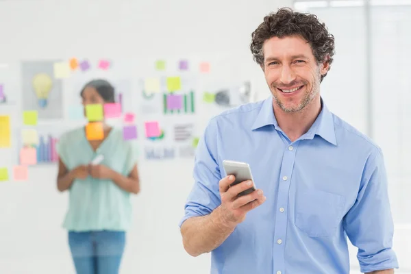 Businessman calling while his colleague posing — Stockfoto