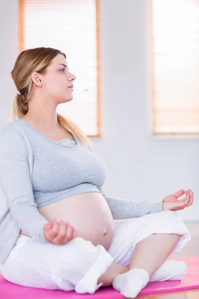 Mujer embarazada haciendo yoga —  Fotos de Stock