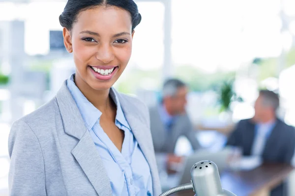 Feliz mujer de negocios con sus colegas detrás — Foto de Stock