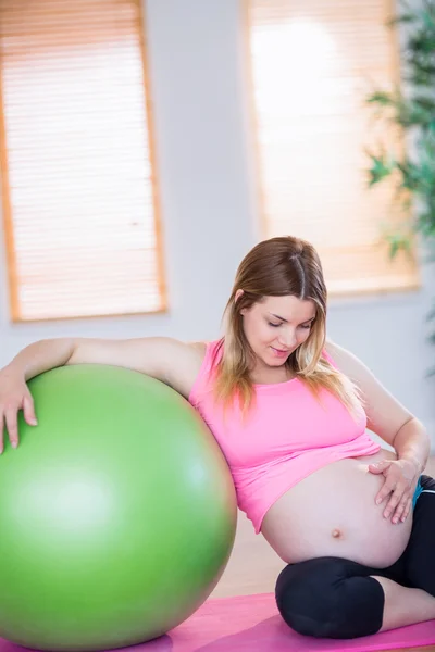Беременная женщина рядом с мячом для упражнений — стоковое фото