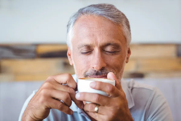 Мужчина, сидящий в кафе и пьющий кофе — стоковое фото