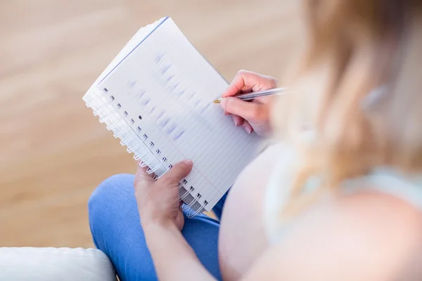 Mulher grávida escrevendo algumas notas — Fotografia de Stock