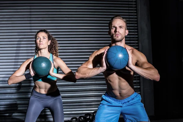Muskulös par gör boll övning — Stockfoto