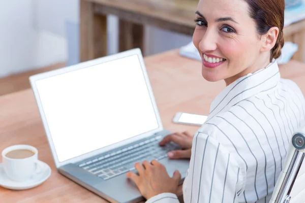 Μελαχρινή επιχειρηματίας χαμογελώντας χρησιμοποιώντας φορητό υπολογιστή — Φωτογραφία Αρχείου